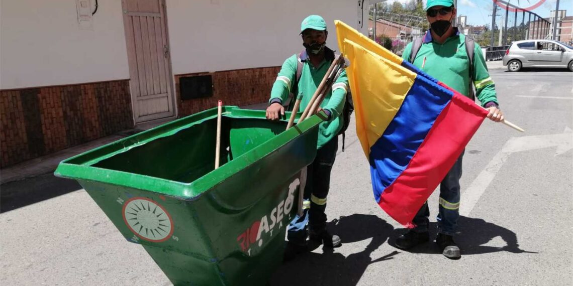 Trabajadores de la Empresa Río Aseo Total, cumpliendo sus labores y ondeando con orgullo la Bandera de Colombia
